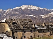 09 Sciolta le neve sui tetti a piode del borgo di Arnosto, ancora ben imbiancato il Resegone